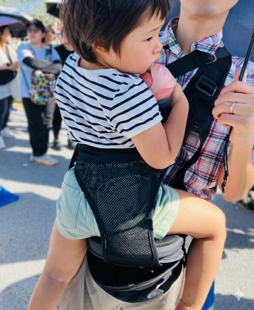 ショルダー付きポルバンベーシック（ヒップシート）に抱かれて静かに過ごしている様子.